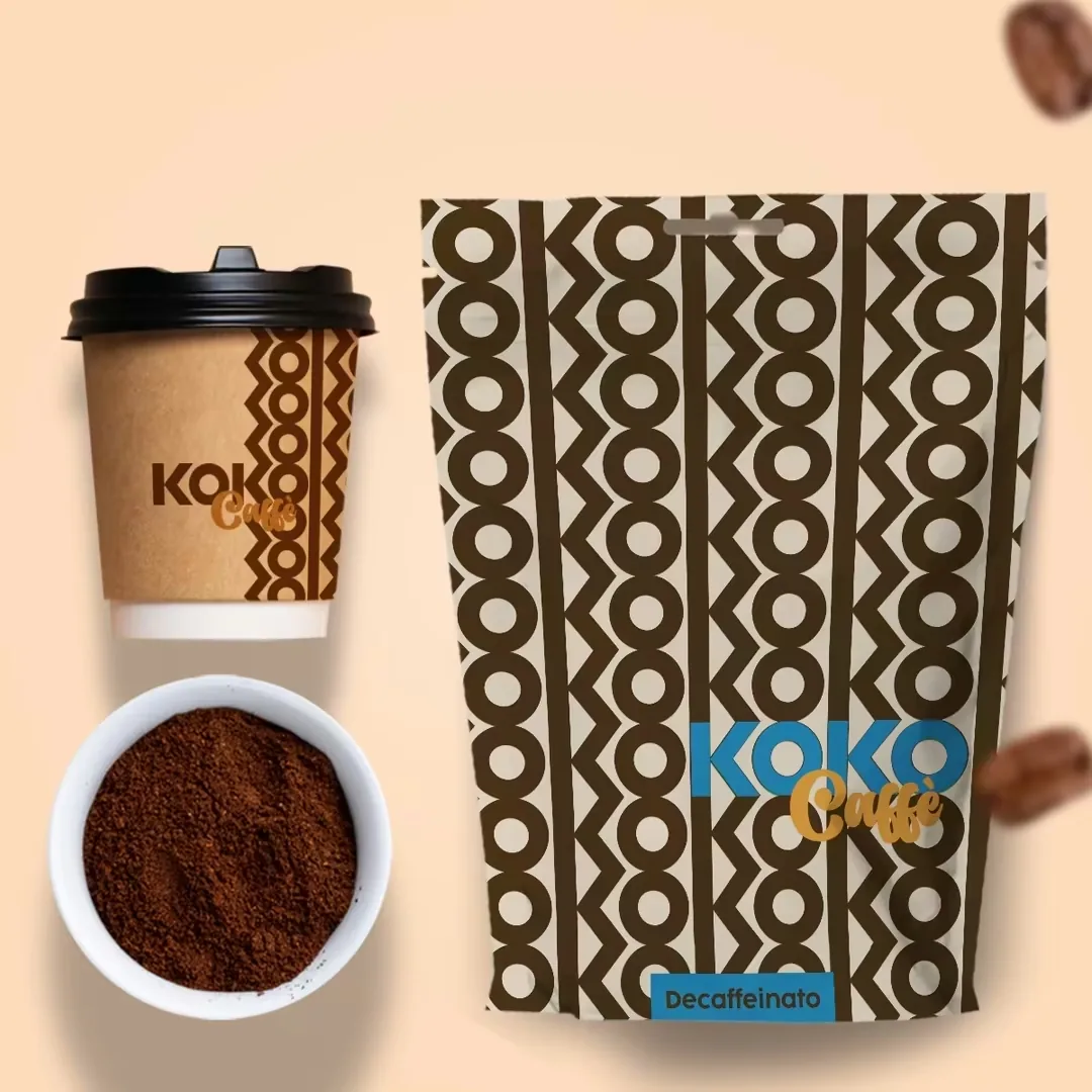 Busta doypack del decaffeinato Koko Caffè con fascia azzurra e bicchiere da asporto in cartoncino kraft